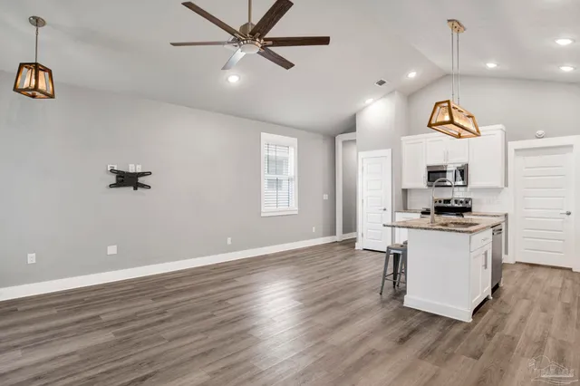 a kitchen with a refrigerator and a stove top oven