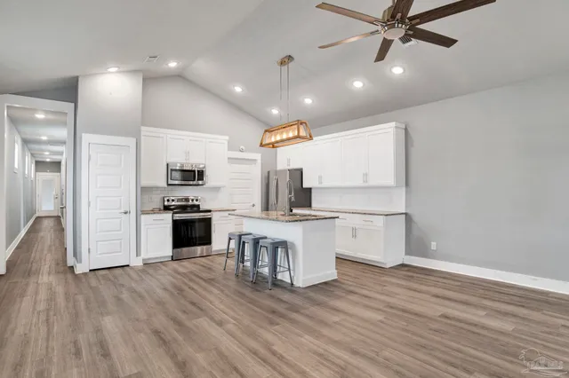 a kitchen with white cabinets and stainless steel appliances