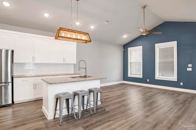 a kitchen with stainless steel appliances granite countertop a stove a sink and a refrigerator