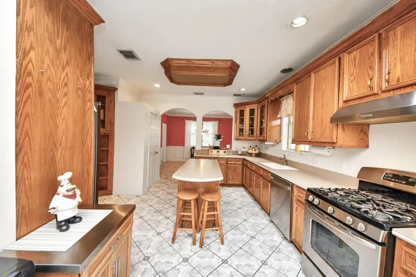 a kitchen with stainless steel appliances granite countertop a stove a sink and a refrigerator