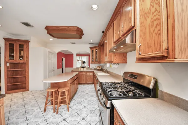 a kitchen with stainless steel appliances granite countertop a stove a sink dishwasher and cabinets with wooden floor