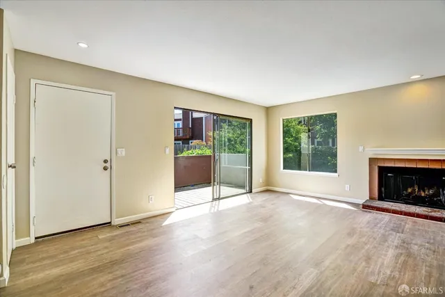 an empty room with floor to ceiling window and fireplace