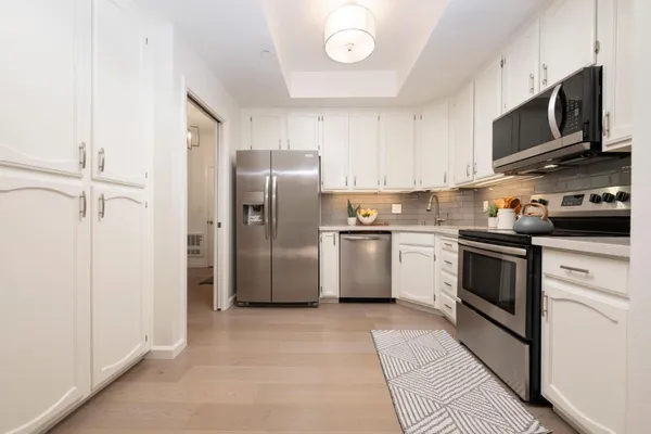 a kitchen with stainless steel appliances a refrigerator sink and microwave