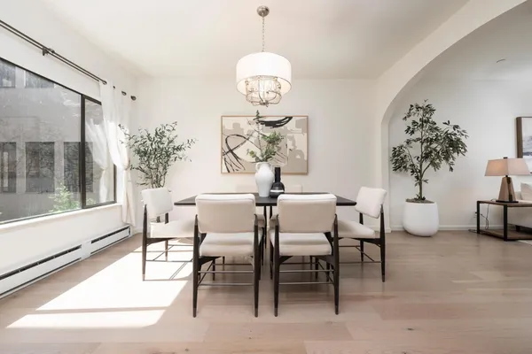 a dining room with chandelier and wooden floor