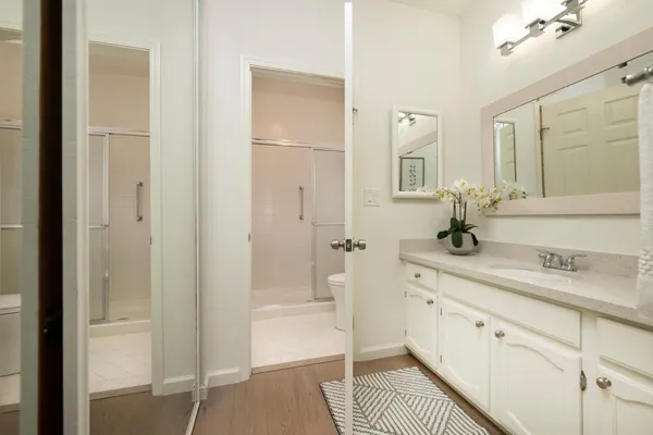 a spacious bathroom with a shower a sink and a mirror