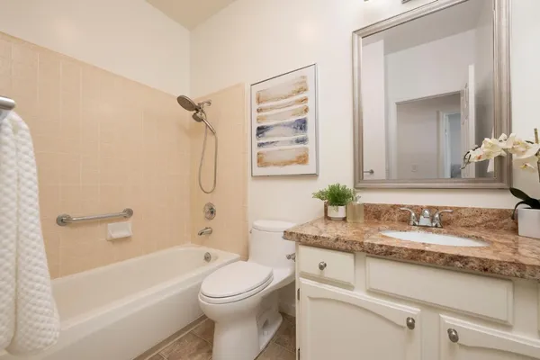 a bathroom with a granite countertop sink a toilet and a bathtub