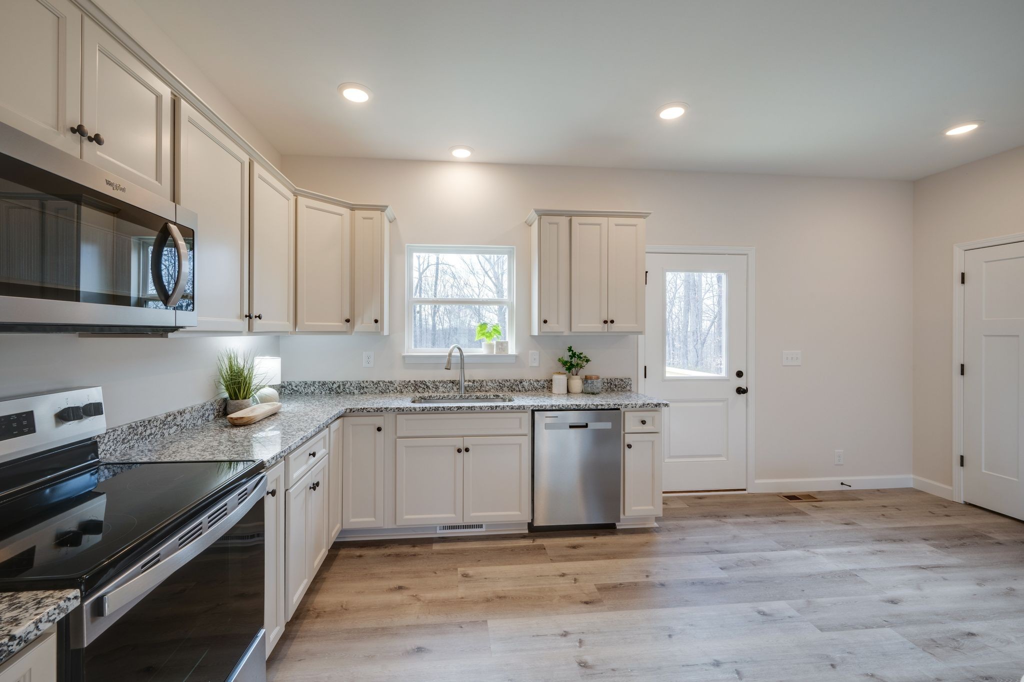 3033 Bowker Road Charlotte, TN 37036 - Photo 11 of 30 a kitchen with stainless steel appliances granite countertop a stove a sink and a microwave