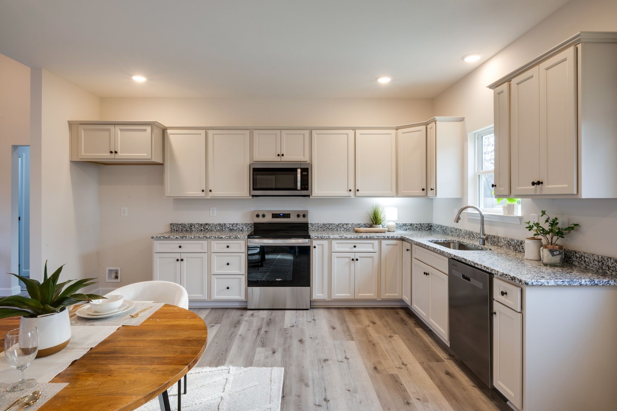 3033 Bowker Road Charlotte, TN 37036 - Photo 12 of 30 a kitchen with stainless steel appliances kitchen island granite countertop a sink stove refrigerator and white cabinets with wooden floor