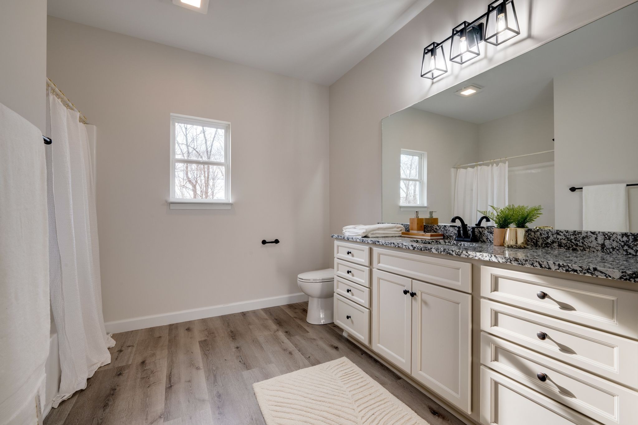 3033 Bowker Road Charlotte, TN 37036 - Photo 18 of 30 a spacious bathroom with a granite countertop sink and a mirror
