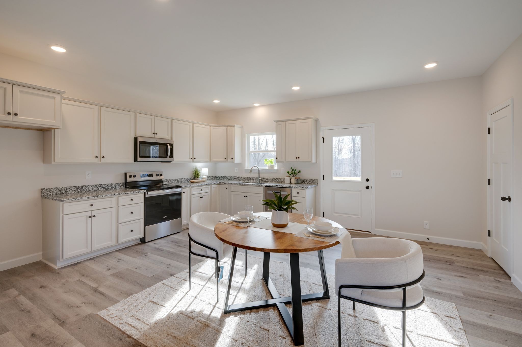 3033 Bowker Road Charlotte, TN 37036 - Photo 8 of 30 a kitchen with a dining table chairs stainless steel appliances and cabinets