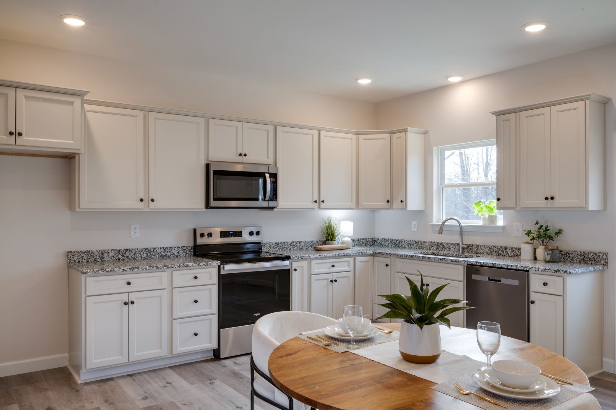 3033 Bowker Road Charlotte, TN 37036 - Photo 9 of 30 a kitchen with granite countertop kitchen island white cabinets sink and stainless steel appliances