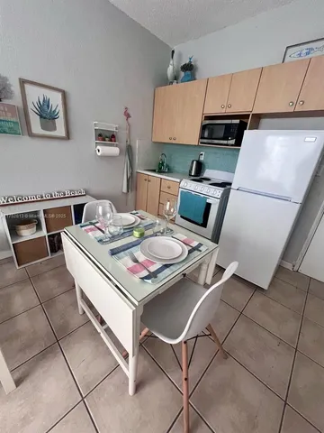 a kitchen with kitchen island a stove a sink dishwasher and white cabinets