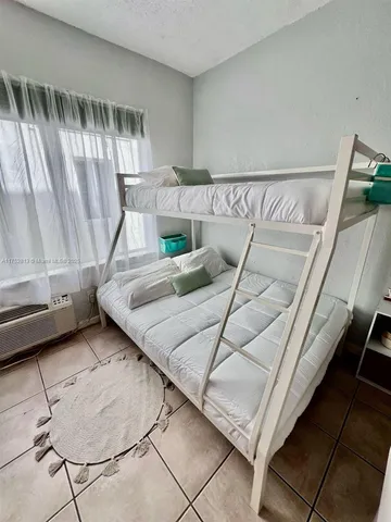 a bedroom with a bed and a mirror on the wall