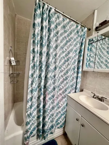 a bathroom with a sink and a shower curtain
