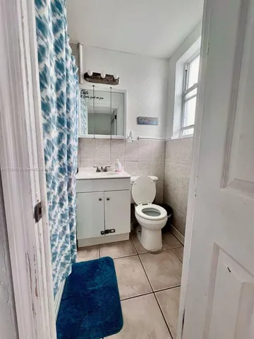 a bathroom with a toilet a sink and a window