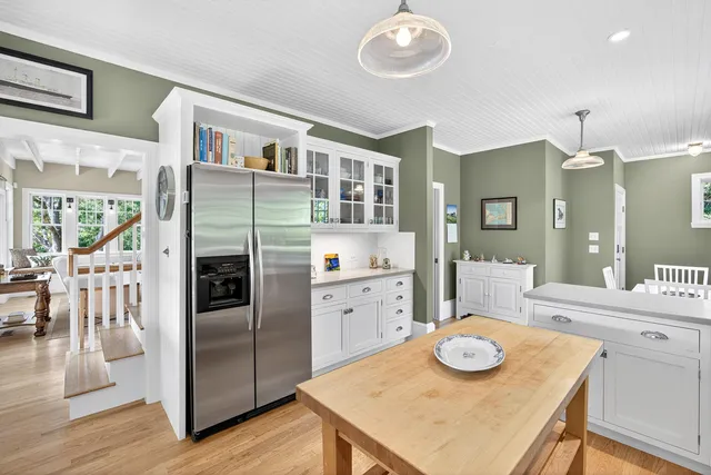 a kitchen with a table chairs and refrigerator