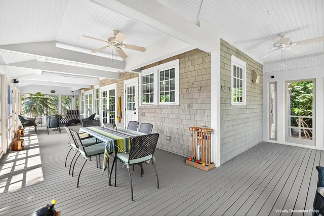 a dining room with wooden floor a chandelier a glass table and chairs