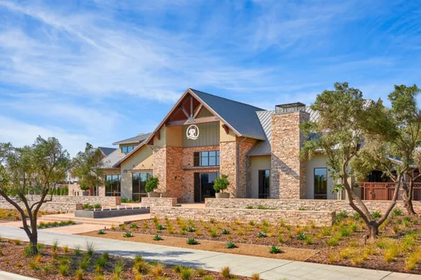 a view of a garden with a car park in front of it