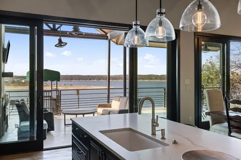 a kitchen with a sink a counter top space and a view of dining room