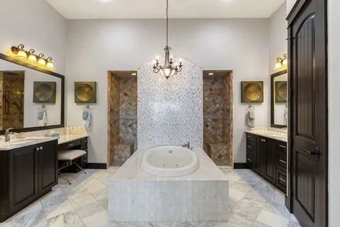 a spacious bathroom with a tub sink and mirror