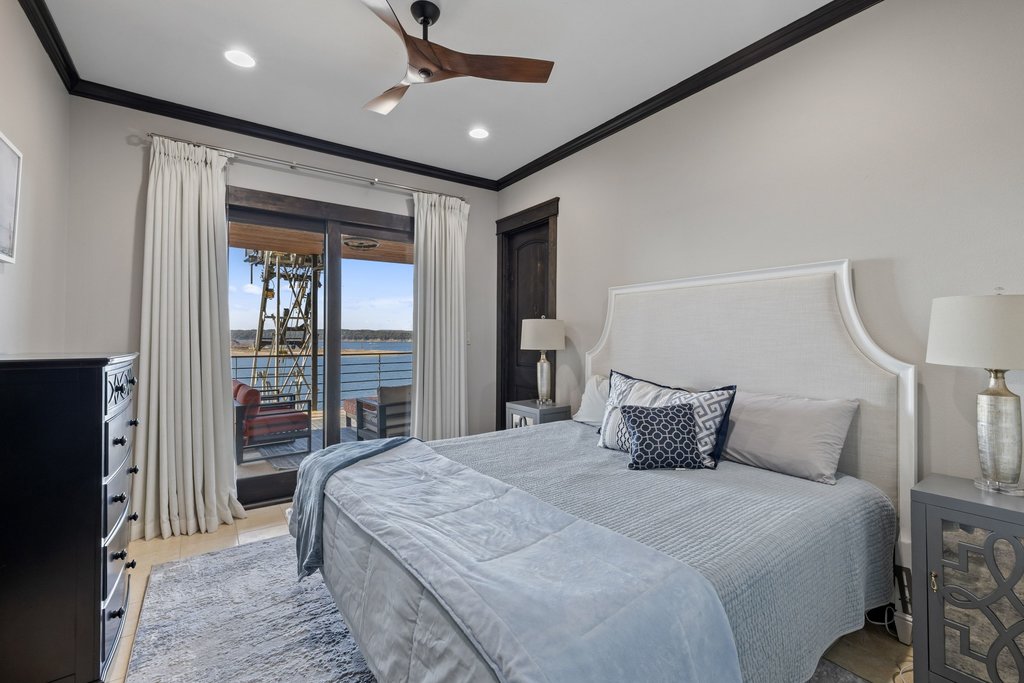 1606 Buffalo Gap Road Austin, TX 78734 - Photo 31 of 40 a bedroom with a large bed and a chandelier