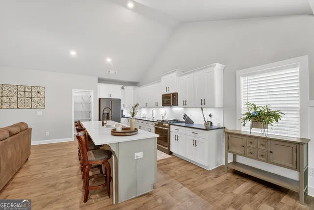 a kitchen with stainless steel appliances kitchen island granite countertop a sink and cabinets