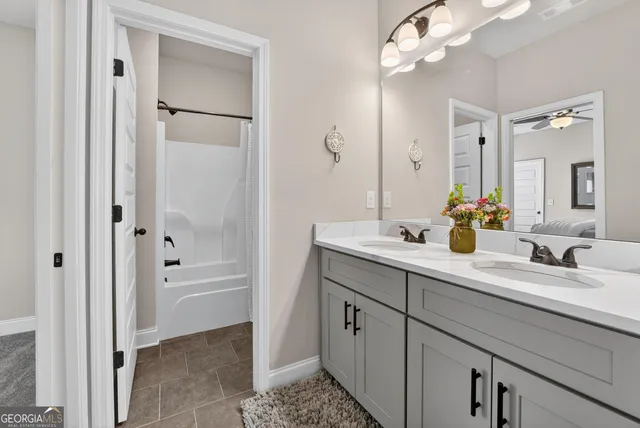 a bathroom with a double vanity sink a mirror and a bathtub