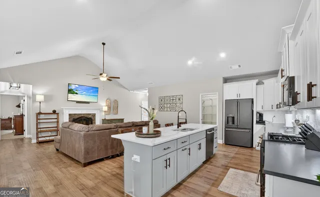 a open kitchen with stainless steel appliances granite countertop a sink refrigerator and cabinets