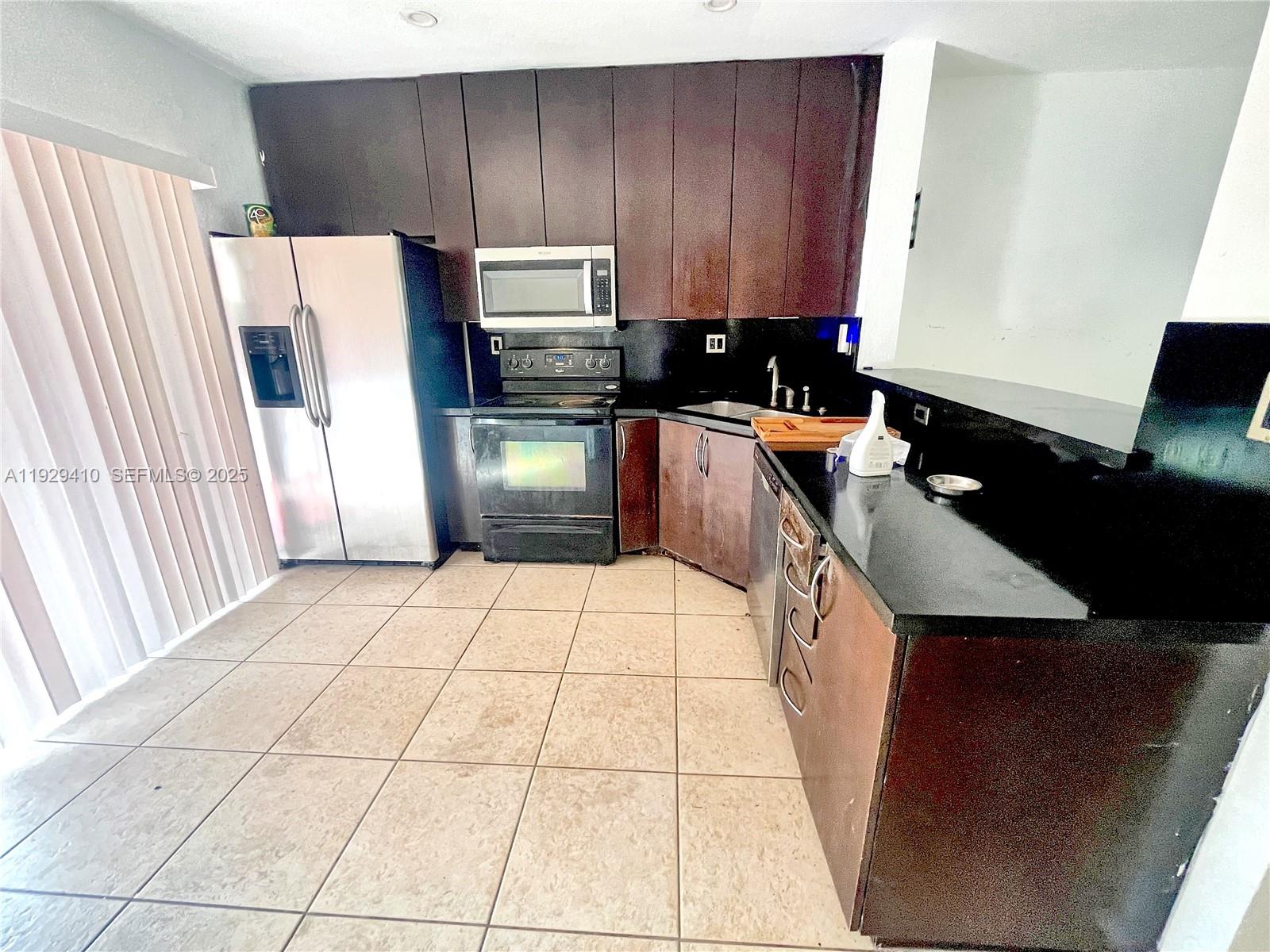 220 East 4th Street, Unit 3 Hialeah, FL 33010 - Photo 7 of 22 a kitchen with a refrigerator a stove a sink and a counter top