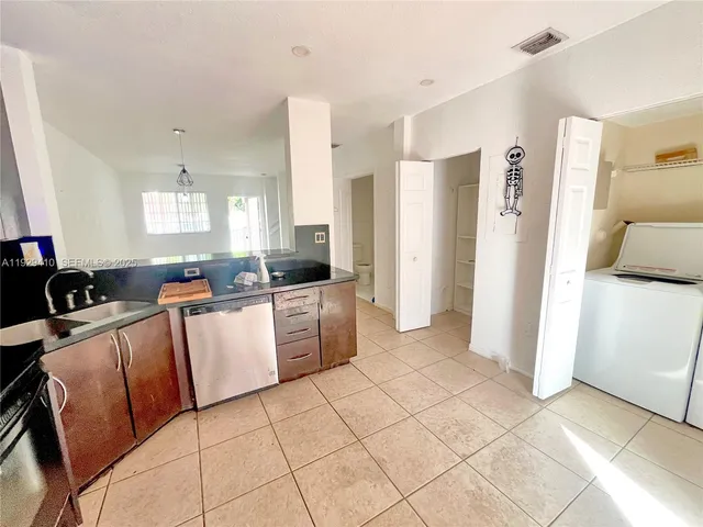 a large kitchen with a stove a refrigerator a sink a dining table and chairs