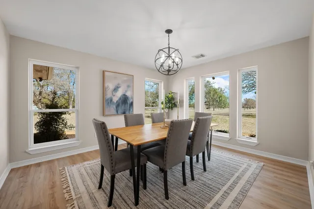 a view of a dining room with furniture wooden floor and a chandelier