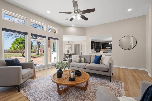 a living room with fireplace furniture and a large window