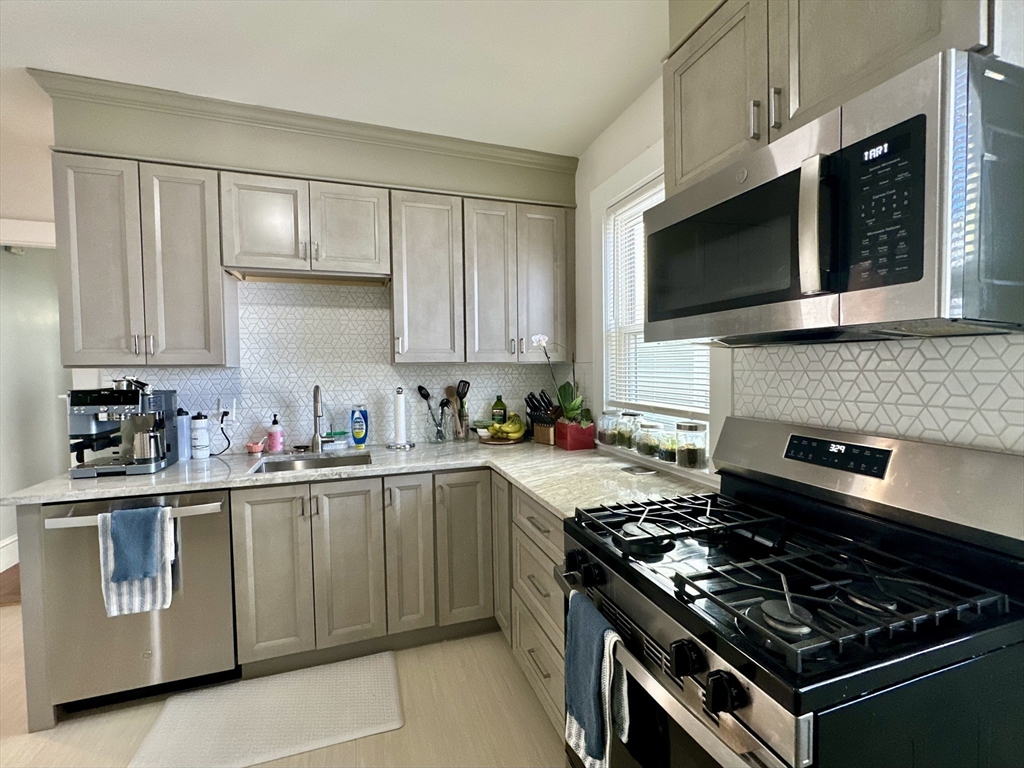 369 Centre Street, Unit 2 Boston, MA 02122 - Photo 2 of 16 a kitchen with stainless steel appliances a sink dishwasher a stove and a microwave