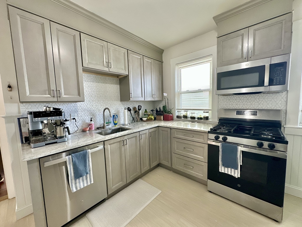 369 Centre Street, Unit 2 Boston, MA 02122 - Photo 3 of 16 a kitchen with stainless steel appliances granite countertop a stove and a sink