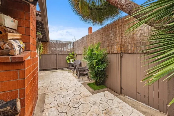 a backyard of a house with potted plants and covered with wooden fence
