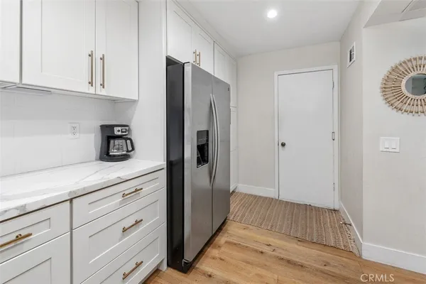 a view of a kitchen with refrigerator and cabinets