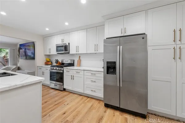 a kitchen with white cabinets and stainless steel appliances