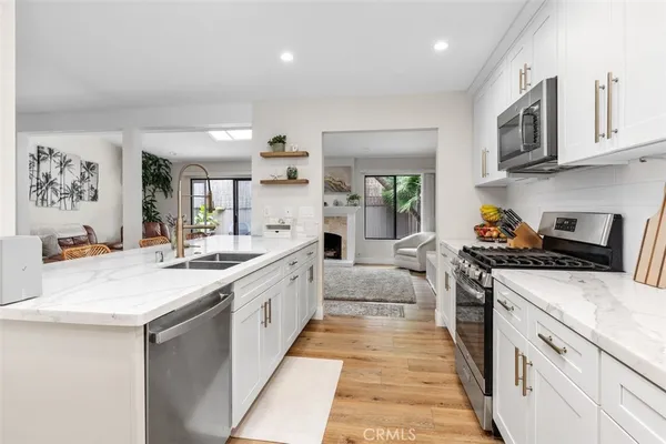 a large kitchen with stainless steel appliances granite countertop a lot of counter space and wooden floors