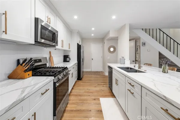 a kitchen with stainless steel appliances granite countertop a stove a sink and a microwave