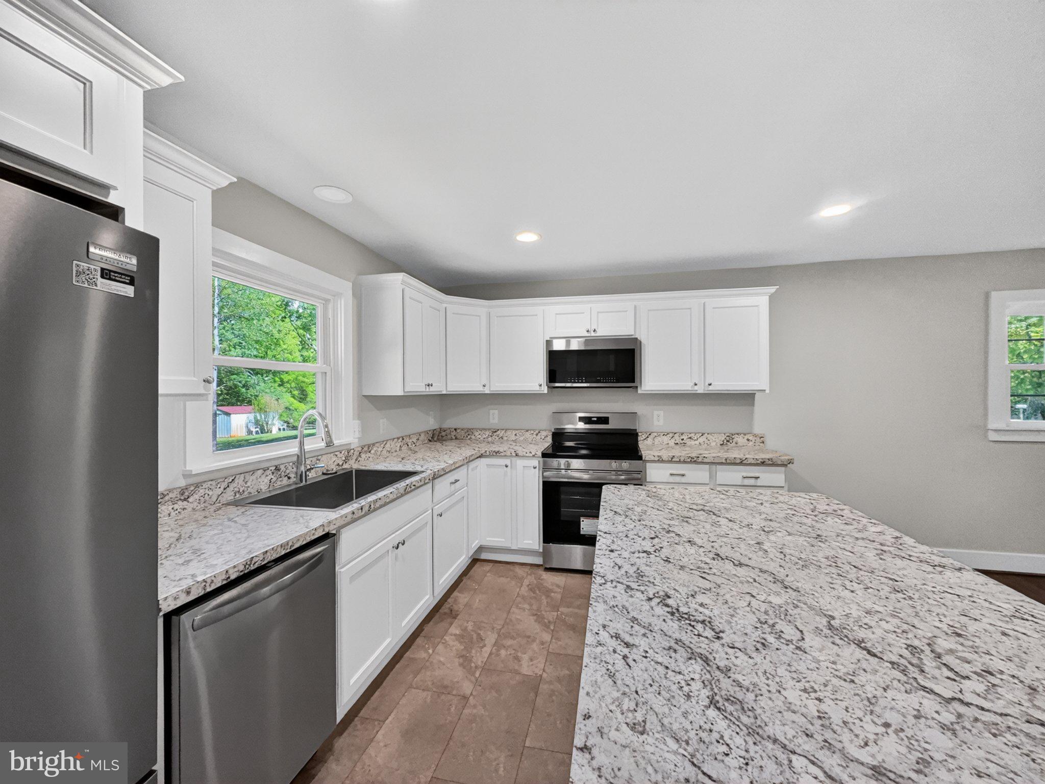 5408 Towles Mill Road Partlow, VA 22534 - Photo 13 of 24 a kitchen with stainless steel appliances granite countertop a refrigerator sink and stove