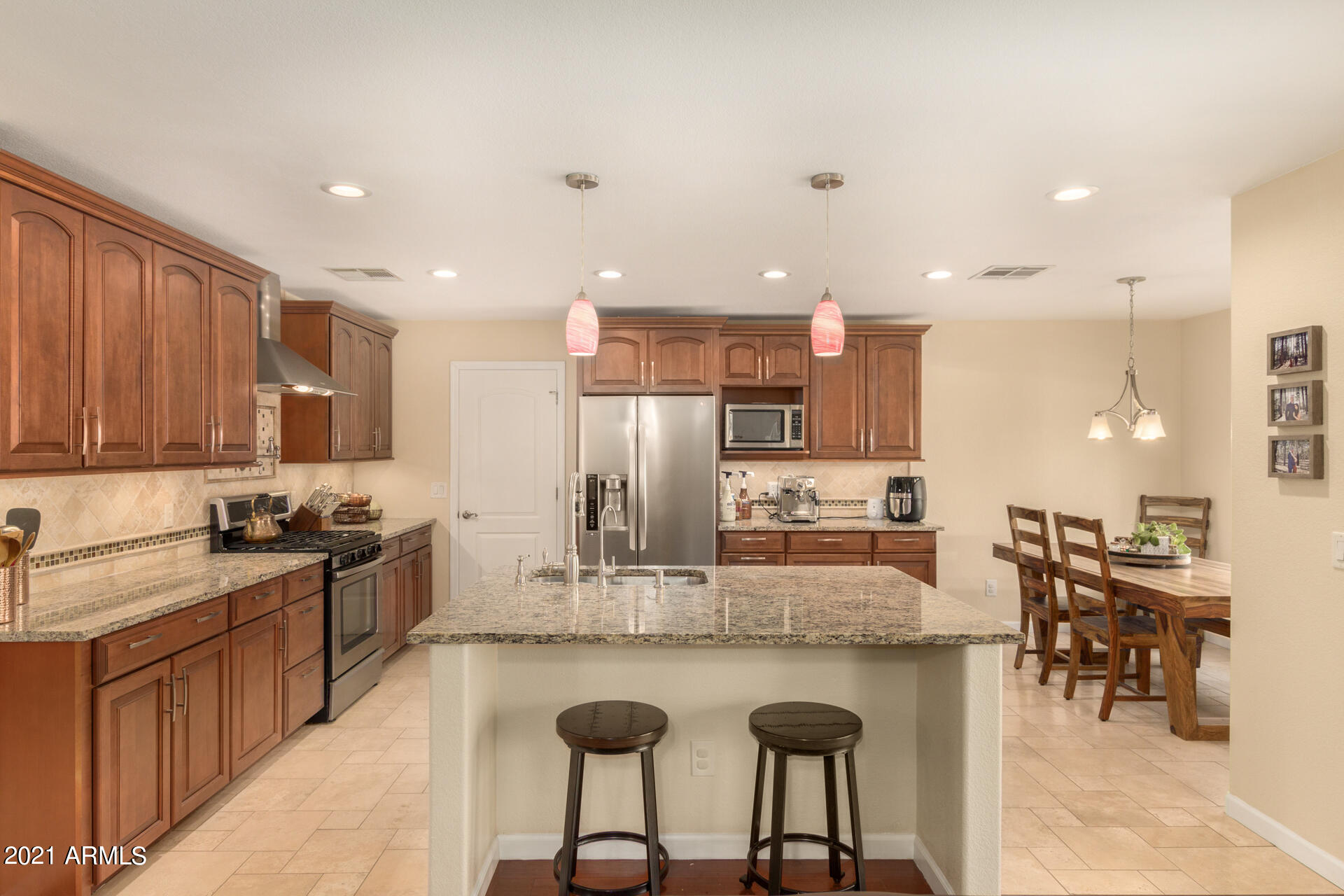 1250 South Palm Street Gilbert, AZ 85296 - Photo 13 of 45 a kitchen with stainless steel appliances granite countertop table chairs stove and refrigerator