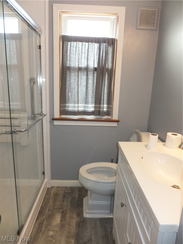 4408 Fulton Road Cleveland, OH 44144 - Photo 10 of 22 Bathroom with toilet, vanity, an enclosed shower, and hardwood / wood-style floors