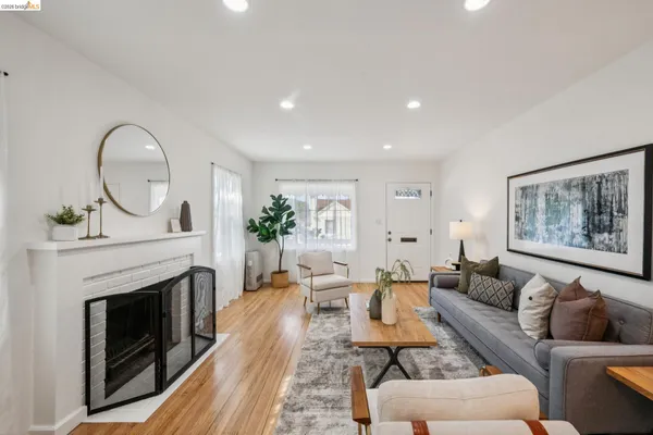 a living room with furniture a fireplace and a potted plant