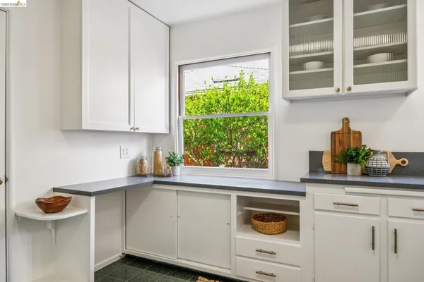 a kitchen with stainless steel appliances granite countertop white cabinets and a window