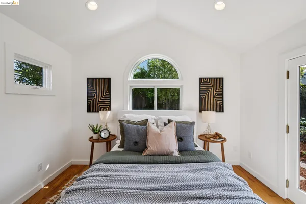 a bedroom with a large window and a potted plant