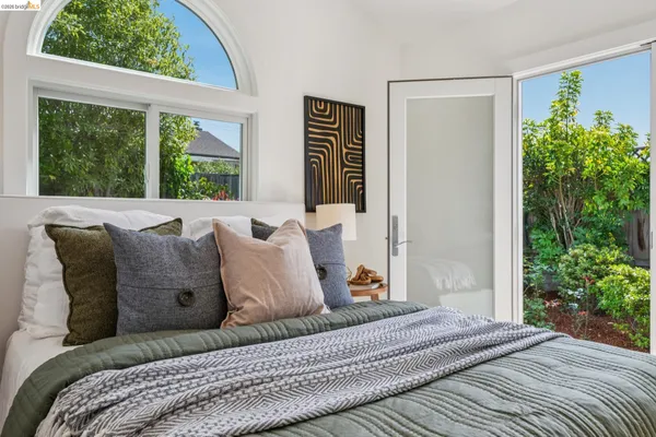a bed sitting in a bedroom next to a window