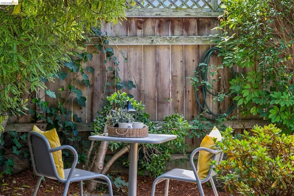 a backyard with table and chairs with potted plants