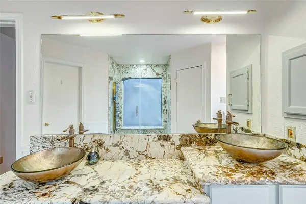 a bathroom with a granite countertop sink and a mirror