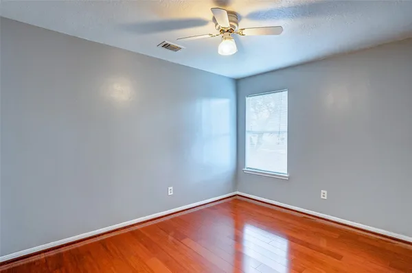 an empty room with a window and a fan