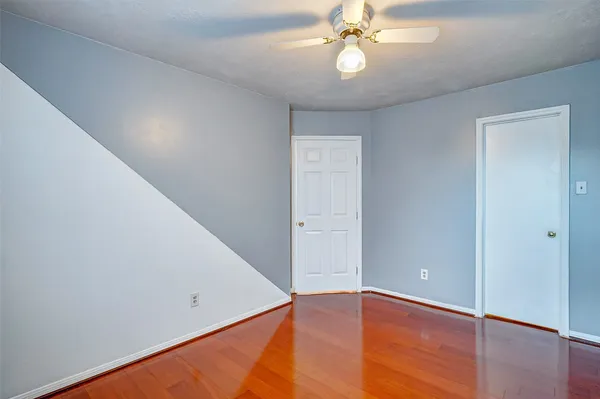 a view of an empty room with wooden floor